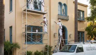 Painting company team in Los Angeles, CA painting a home exterior with professional tools